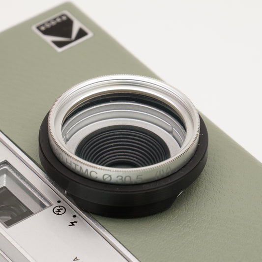 Filteradapter mit aufgeschraubtem Filter auf dem Objektiv einer grünen Kodak Ektar H35 Kamera
