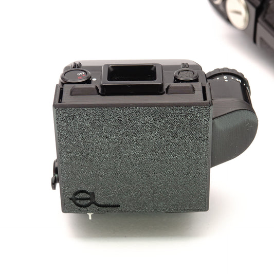 Schwarzer Schutzdeckel auf einer analogen Minolta XM Kamera montiert