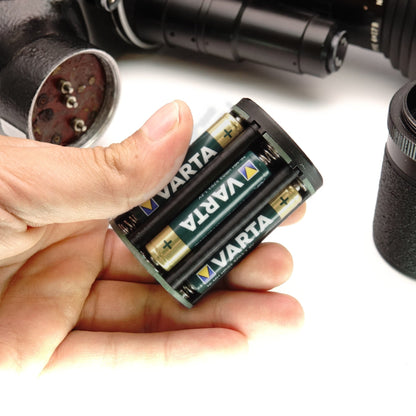 Hand hält gefüllten Batteriehalter mit eingelegten Akkus für eine Beaulieu R16 Filmkamera