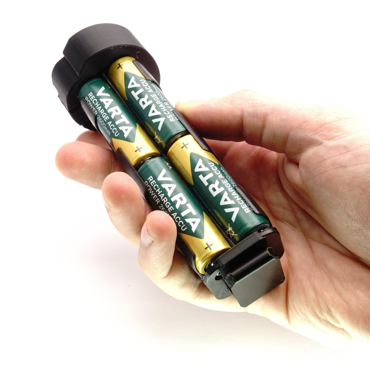 Hand hält mit vier eingelegten Mignon-Akkus bestückten Batterieadapter für Metz Blitzgeräte