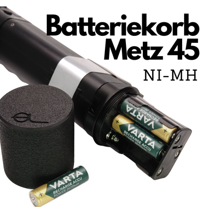 Geöffneter Batteriekorb Metz 45 NiMH mit eingelegten Varta Akkus neben der zylindrischen Schutzkappe mit eingeprägtem Logo