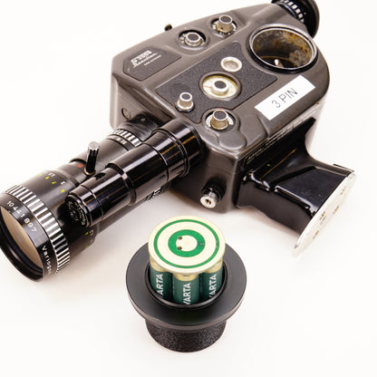 Batterieadapter bestückt mit zwei grünen Akkus vor einer Beaulieu S2008 Schmalfilmkamera