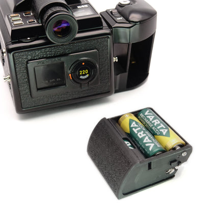 Mit zwei eingelegten Batterien vor einer Pentax 645 Kamera