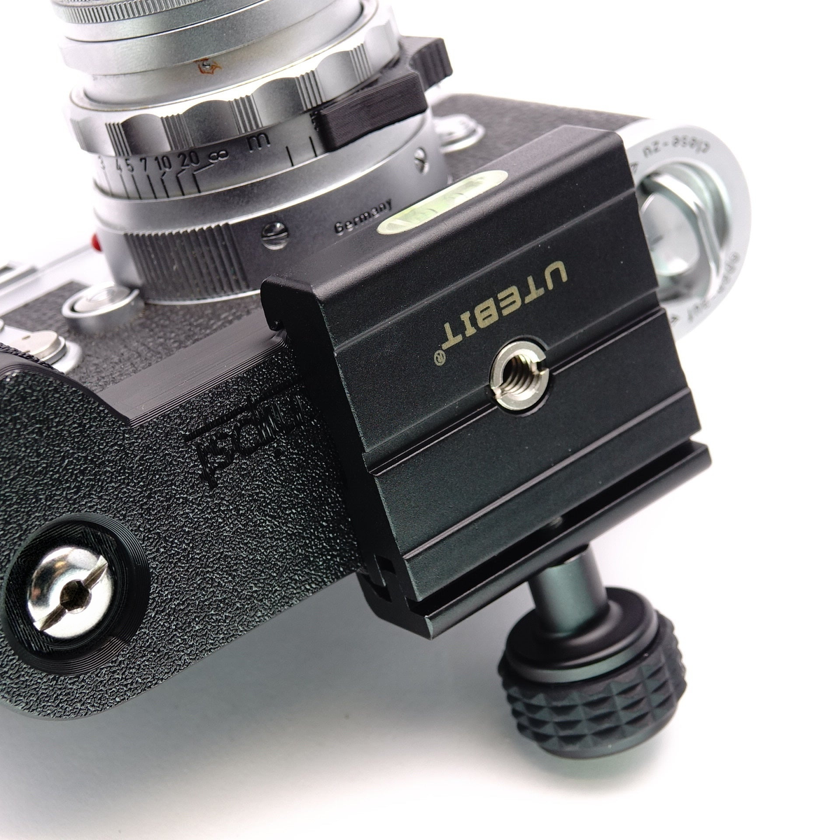 Unterseite einer Leica M mit montiertem Handgriff und Arca Swiss kompatibler Schnellwechselplatte mit Stativgewinde